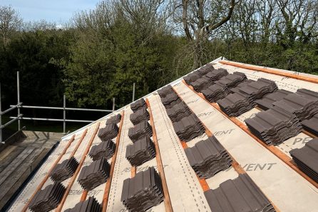 Roofing tiles arranged on a wooden framework, ready for installation on a sloped roof.